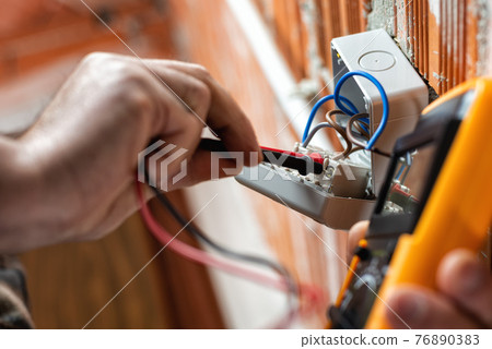 Electrician at work on a residential electrical system. Electricity. Electrician at work on a residential electrical system. Electricity. 76890383