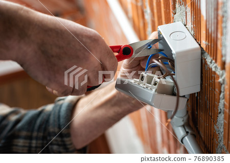 Electrician at work on a residential electrical system. Electricity. 76890385