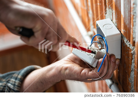 Electrician at work on a residential electrical system. Electricity. Electrician at work on a residential electrical system. Electricity. 76890386