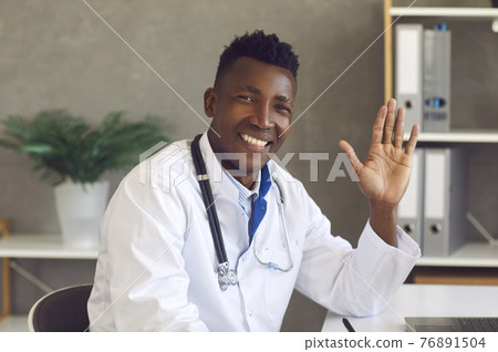 Headshot of happy African-American doctor looking at camera, smiling and waving hand Headshot of happy African-American doctor looking at camera, smiling and waving hand 76891504