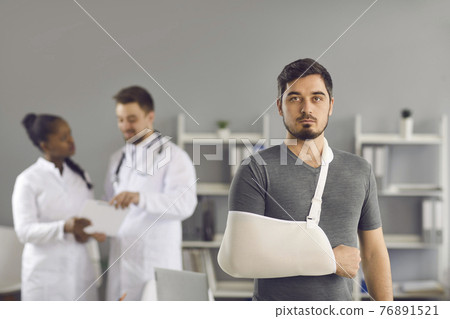Serious man patient with broken arm wrapped on orthopedic bandage portrait Serious man patient with broken arm wrapped on orthopedic bandage portrait 76891521