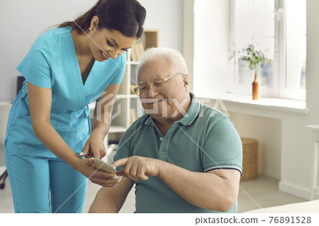 Friendly doctor teaching senior man to use special health indicator mobile app 76891528