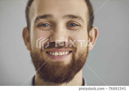 Closeup studio portrait of a happy friendly bearded young man smiling at the camera 76891541