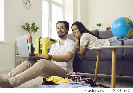 Young couple planning holiday trip and using laptop to buy tickets or book hotel room 76891587