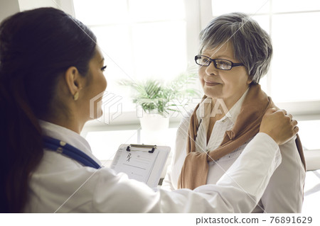 Smiling caring young female nurse doctor support senior woman patient closeup Smiling caring young female nurse doctor support senior woman patient closeup 76891629