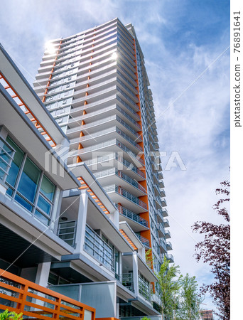 Brand new high-rise building on blue and white sky background Brand new high-rise building on blue and white sky background 76891641
