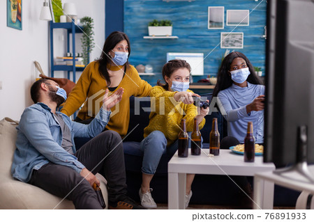 Concentrated multiracial friends playing video games with joystick Concentrated multiracial friends playing video games with joystick 76891933
