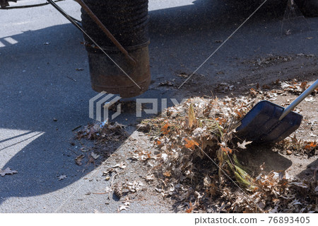 Outdoor manual worker clean the fallen leaves on vacuum up in the road 76893405