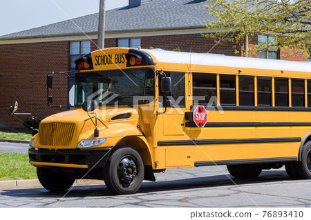 Yellow school bus for children educational transport on the street 76893410