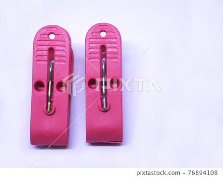 Red plastic clothespin isolated on white background  76894108