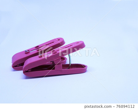 Red plastic clothespin isolated on white background  76894112