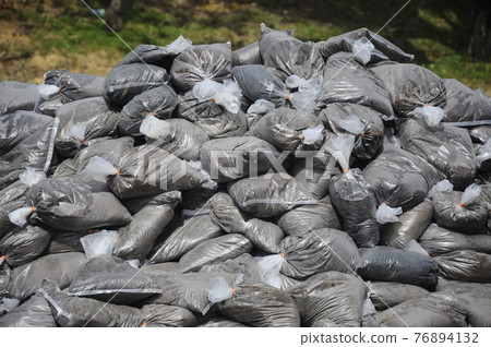 Dump the tree fertilizer which has been mixed with soil and packaged in plastic containers. Dump the tree fertilizer which has been mixed with soil and packaged in plastic containers. 76894132