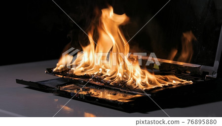 Burning laptop computer electronics closeup Burning laptop computer electronics closeup 76895880