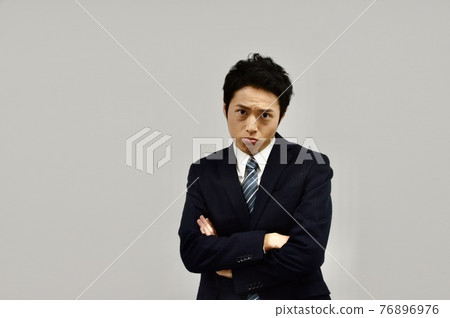 A man glaring with his arms crossed 76896976