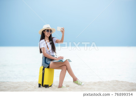 Happy traveler and tourism young women travel summer on the beach 76899354