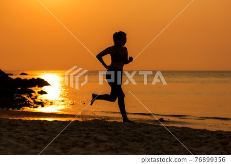 Silhouette athletic woman jogging exercise and relax and freedom on sand beach. Silhouette athletic woman jogging exercise and relax and freedom on sand beach. 76899356