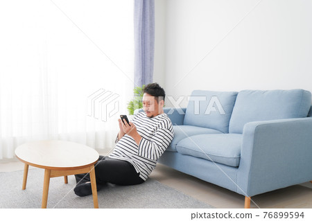 A man using a smartphone in the room A man using a smartphone in the room 76899594