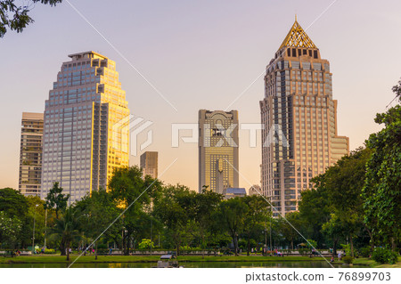 Lumpini park business district Bangkok cityscape from park with sunset sky Lumpini park business district Bangkok cityscape from park with sunset sky 76899703