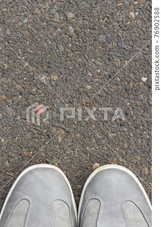 Gray leather shoes on asphalt road or footpath. Male footwear. Copy space for text 76902588