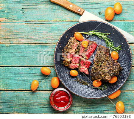 Juicy beef steak with kumquat,wooden table 76903388