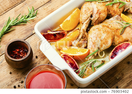 Baked chicken legs with oranges,wooden table Baked chicken legs with oranges,wooden table 76903402