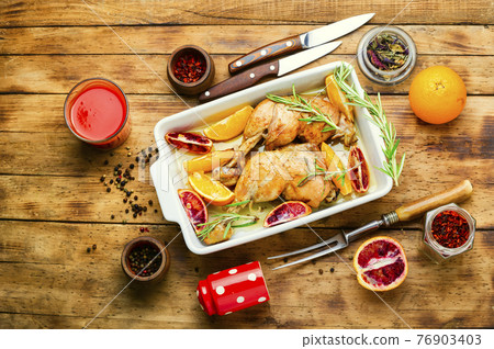 Tasty chicken drumstick baked with oranges,top view Tasty chicken drumstick baked with oranges,top view 76903403