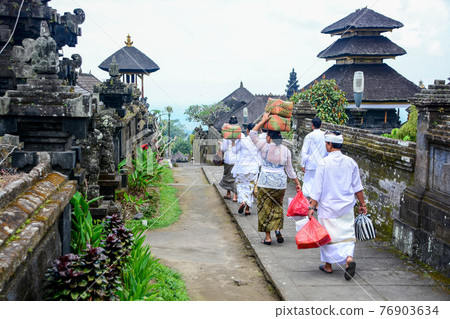 Balinese people walk in traditional dress in Pura Besakih 76903634