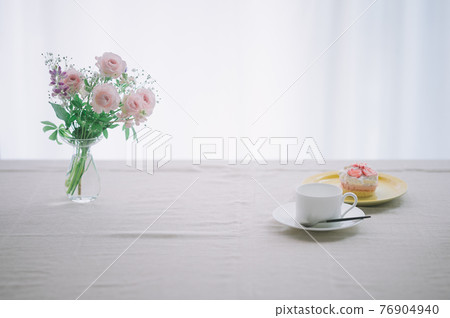 Flowers and cake on the table 76904940