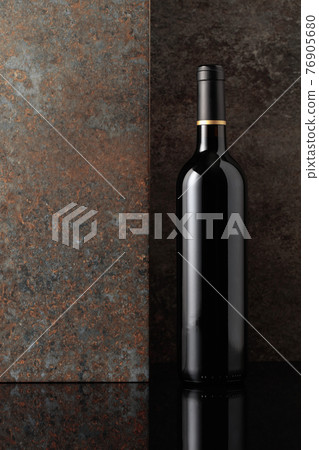 Bottle of red wine on rusty brown background. Bottle of red wine on rusty brown background. 76905680