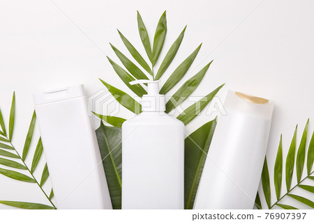 Horizontal shot of cosmetic products against greenery or leaves. Hygiene concept. Cosmetics for you. Set of beauty products Horizontal shot of cosmetic products against greenery or leaves. Hygiene concept. Cosmetics for you. Set of beauty products 76907397