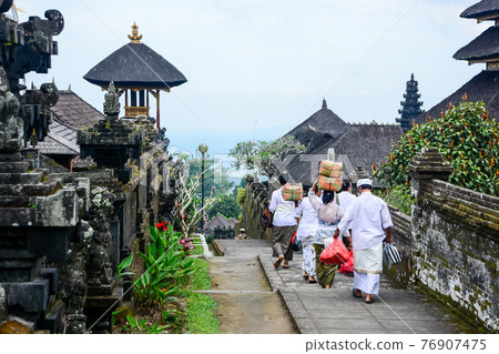 Balinese people walk in traditional dress in Pura Besakih 76907475