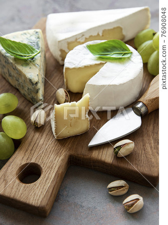 Various types of cheese and snacks 76908048