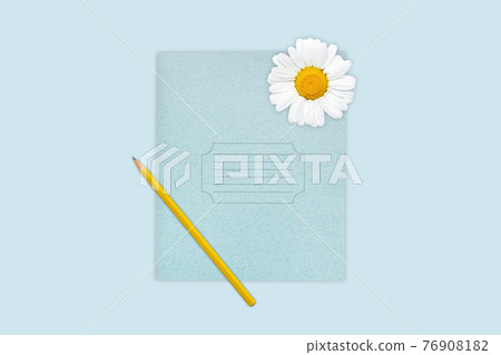 Yellow wooden pencil lying on copybook decorated with camomile. Notebook and pencil isolated over blue background. School supplies. Blank blue copybook for your advertisment or promotional text Yellow wooden pencil lying on copybook decorated with camomile. Notebook and pencil isolated over blue background. School supplies. Blank blue copybook for your advertisment or promotional text 76908182