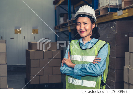 Portrait of young Asian woman warehouse worker smiling in the storehouse Portrait of young Asian woman warehouse worker smiling in the storehouse 76909631