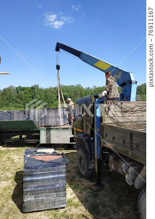 Unloading the front brick using a mobile crane in the village in private territory. 76911167