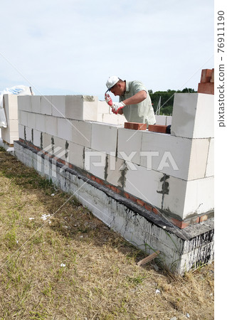 Laying the wall of gas blocks with tools and glue. 76911190