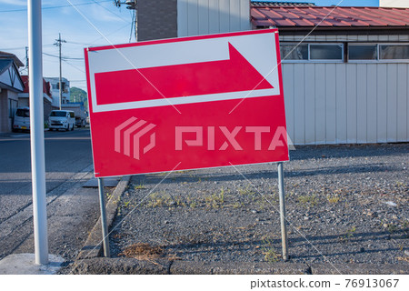 A slightly tilted sign with a red arrow A slightly tilted sign with a red arrow 76913067