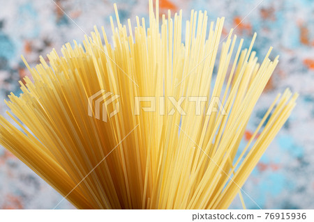 Bunch of spaghetti close-up. Ingredients on the table. Food background.  76915936