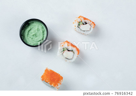 Sushi rolls with red caviar and wasabi sauce 76916342
