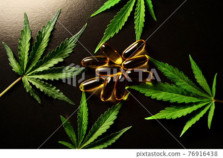 Medicinal cannabis leaves with marijuana oil in capsules on black background Medicinal cannabis leaves with marijuana oil in capsules on black background 76916438