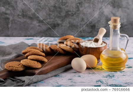 Oatmeal cookies in a wooden platter with ingredients around Oatmeal cookies in a wooden platter with ingredients around 76916666