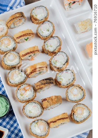 Fried crispy unagi rolls in a white ceramic platter Fried crispy unagi rolls in a white ceramic platter 76916710