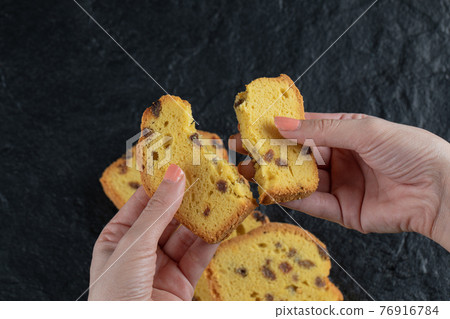 Cutting sultana pie slice into half in the hand Cutting sultana pie slice into half in the hand 76916784