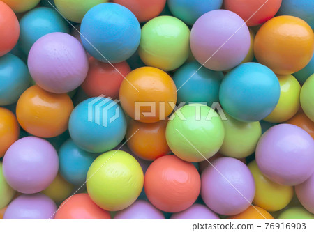 Background from multicolored bright small wooden balls of blue, yellow, red, lilac and green colors. A beautiful summer bright background for your projects. Background from multicolored bright small wooden balls of blue, yellow, red, lilac and green colors. A beautiful summer bright background for your projects. 76916903