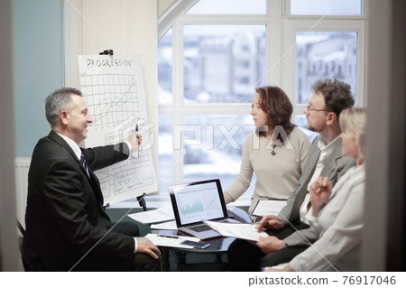 confident businessman showing business partners a new commercial project. confident businessman showing business partners a new commercial project. 76917046