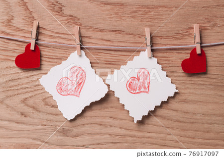 two blank sheets and red hearts with clothespins on a rope 76917097