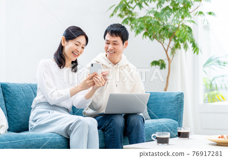 A middle-aged couple relaxing in the living room A middle-aged couple relaxing in the living room 76917281