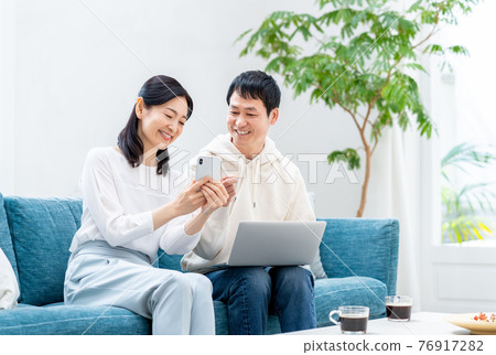 A middle-aged couple relaxing in the living room A middle-aged couple relaxing in the living room 76917282