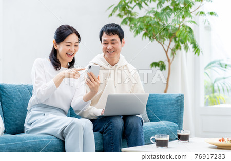 一對中年夫婦在客廳裡放鬆 一對中年夫婦在客廳裡放鬆 76917283