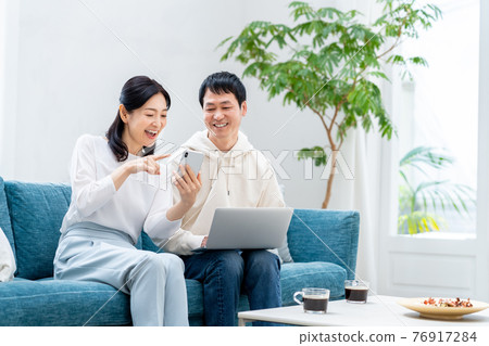 一對中年夫婦在客廳裡放鬆 一對中年夫婦在客廳裡放鬆 76917284